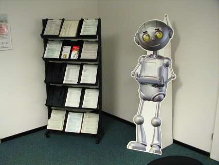 Ein Pappaufsteller, der Broschüren in einer Behörde anbietet, in Form eines Roboters